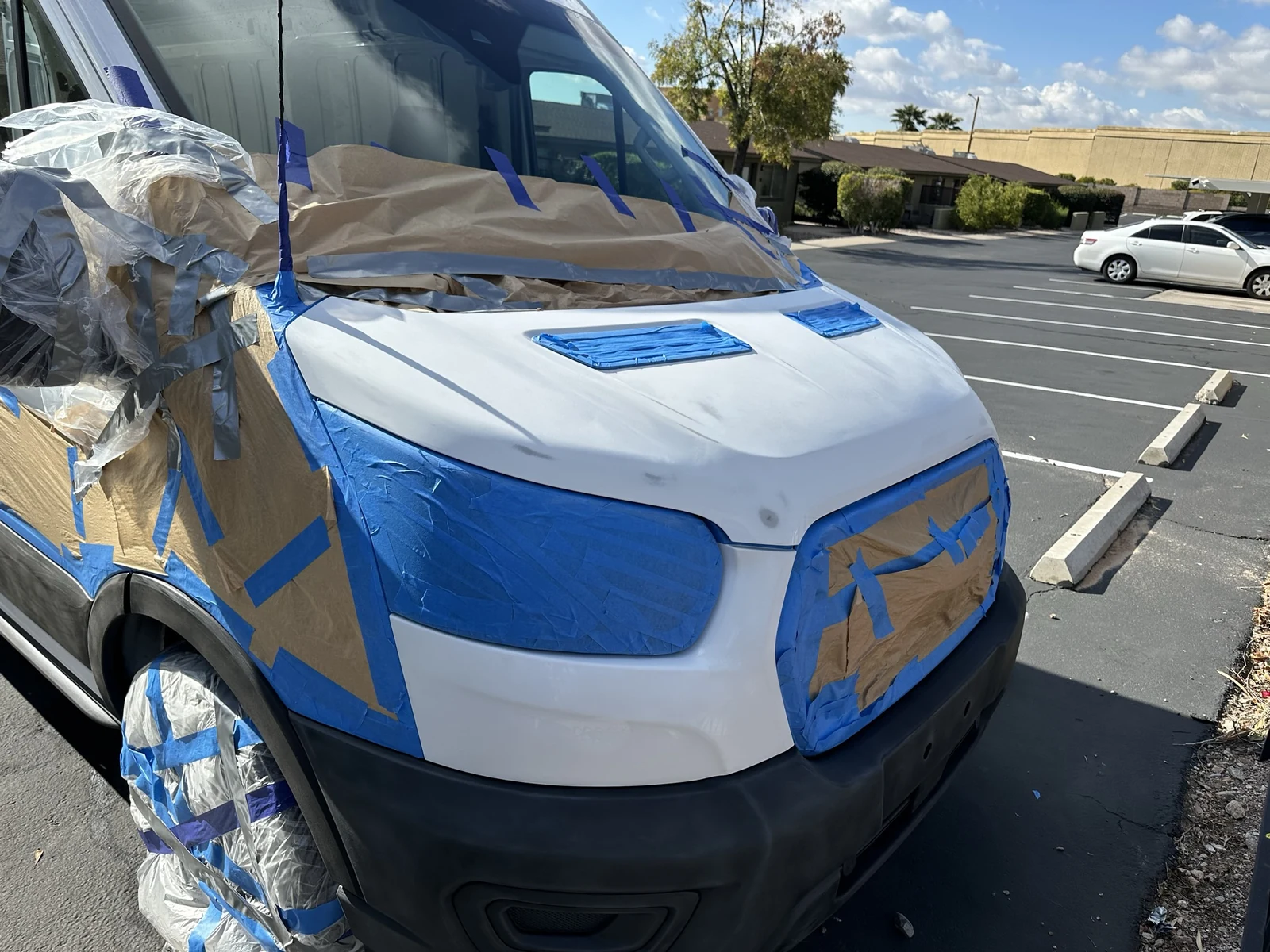 Scuffed white Transit hood with the headlights, grille, vents and windshield edge masked.