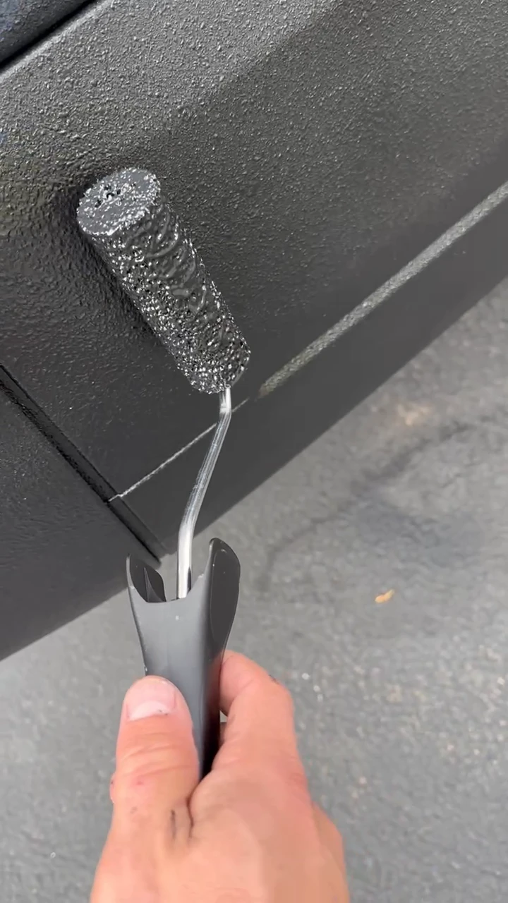 A roller applying black coating to the lower side trim of my Transit.