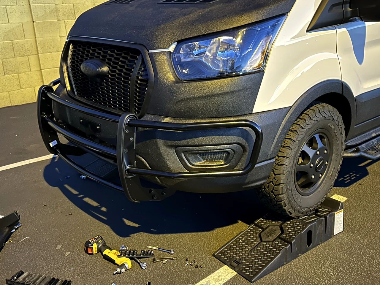 My completed black front grille guard and headlamp wings on the Ford Transit, viewed from the driver’s front corner