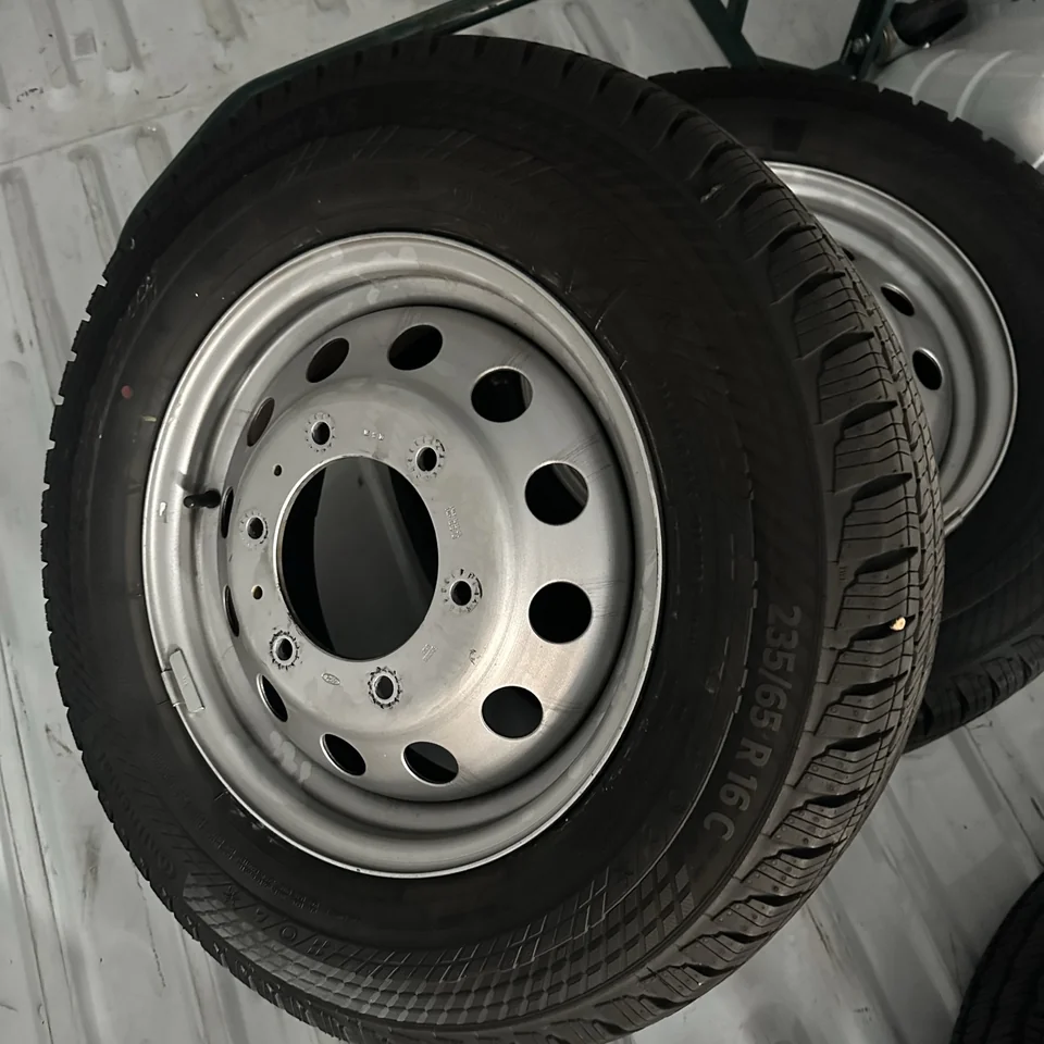 Original silver steel wheel and stock tire, cropped from Steven’s photograph of the removed assembly.