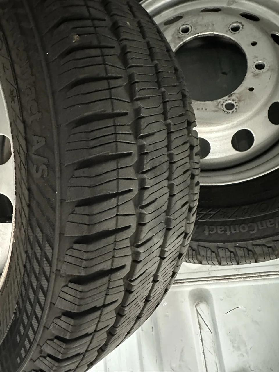 Close-up of the original tire tread with another removed stock wheel behind it.