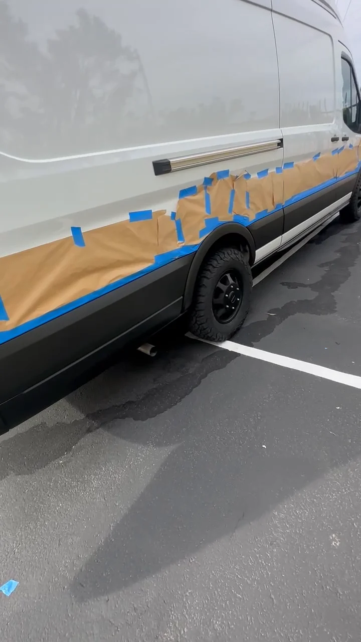 Paper and blue tape defining the lower-trim coating area during my masking walkthrough.