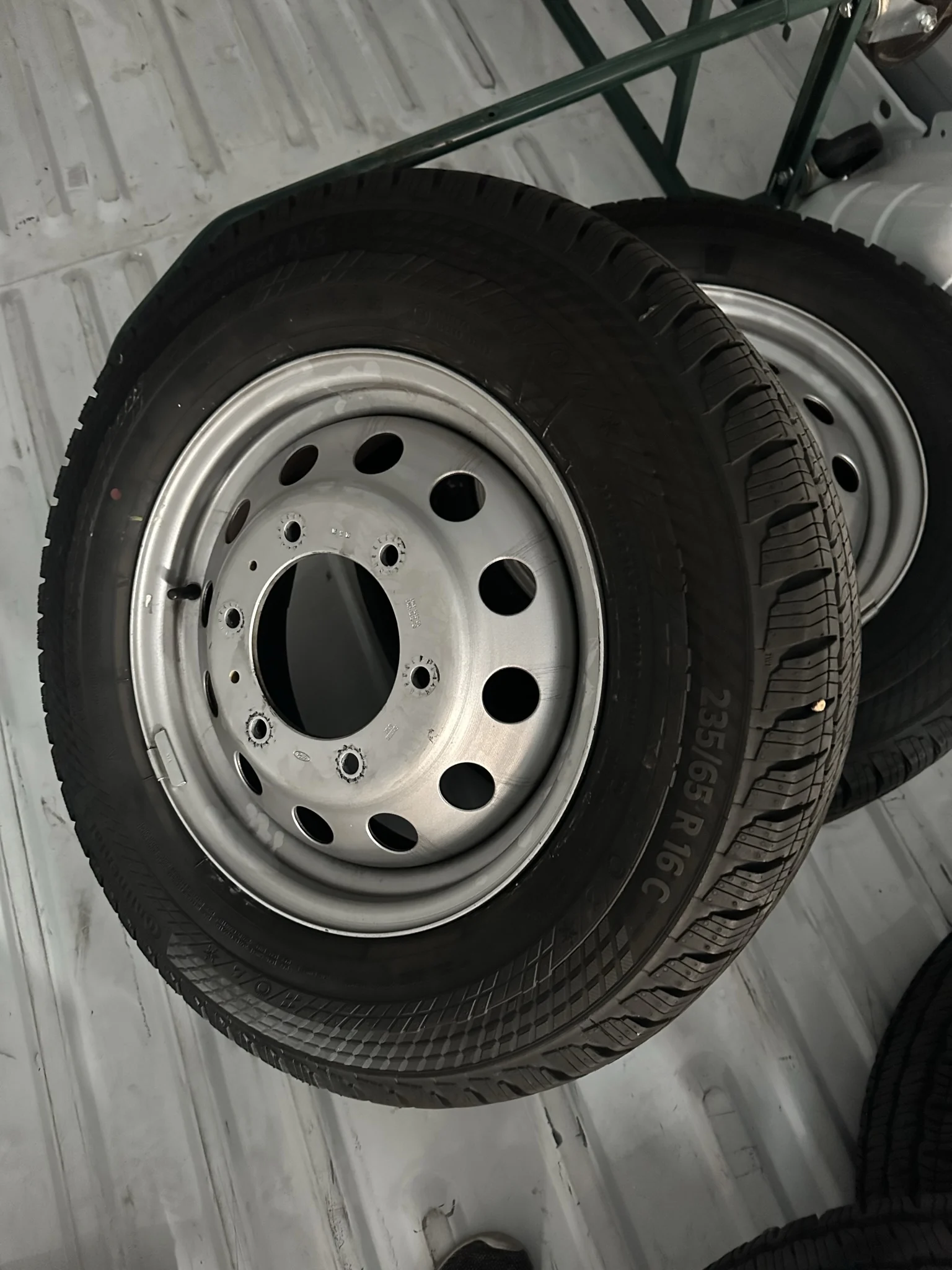 The original silver steel wheel and its readable 235/65 R16C tire marking.