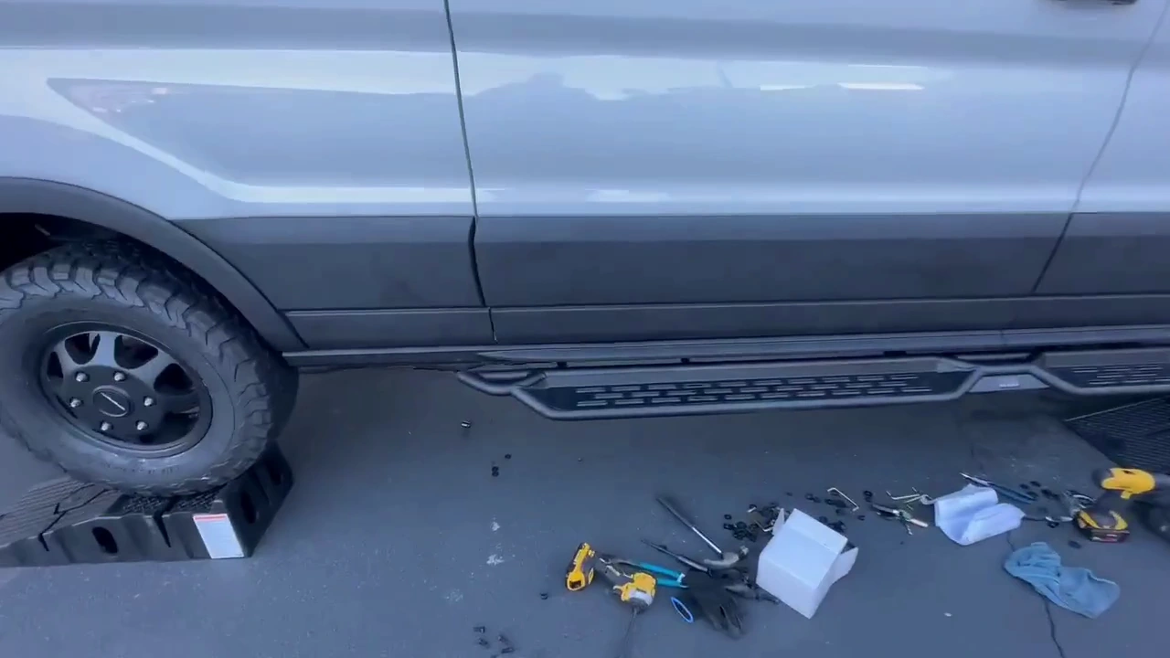 My passenger-side running board installed below the doors, with the work tools still on the pavement.