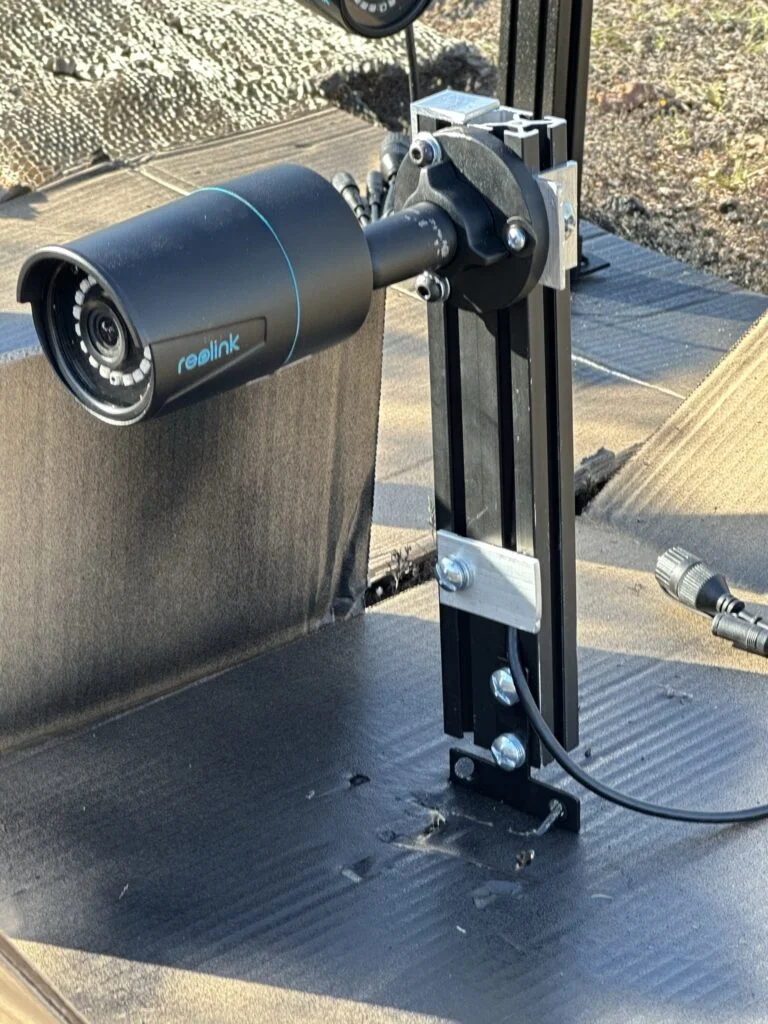 A camera attached to one of the black-finished extrusion mounts.