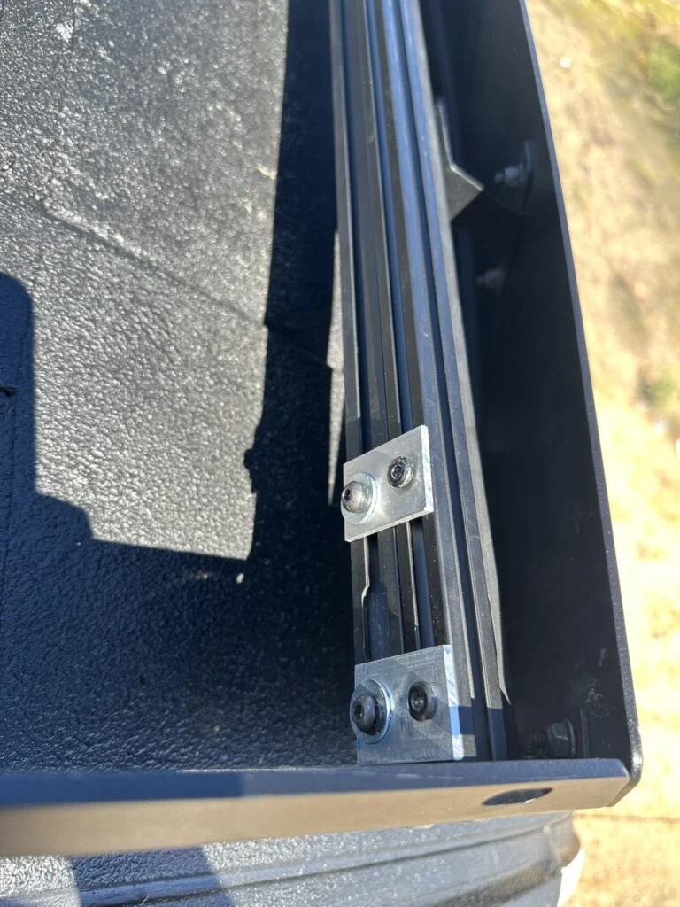 The added extrusion and small connecting brackets beneath the light-bar mounting position.