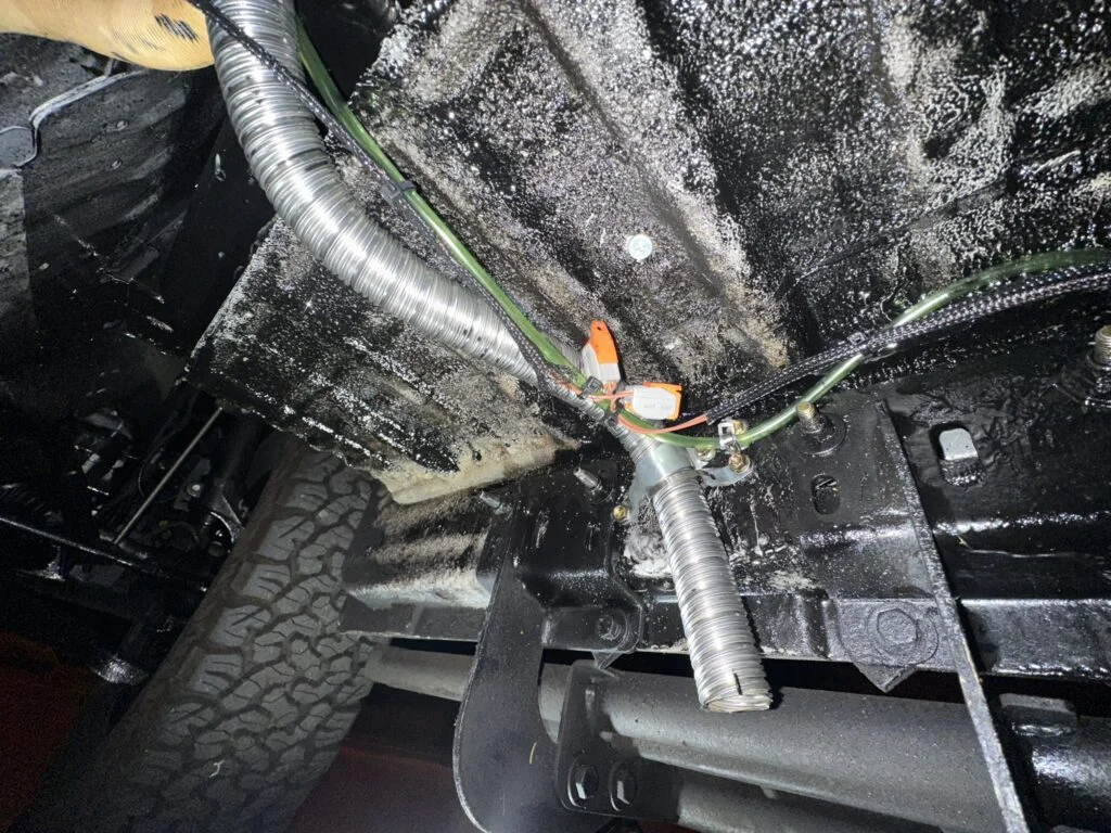 A later view of the fuel-line and wiring route beneath the van.