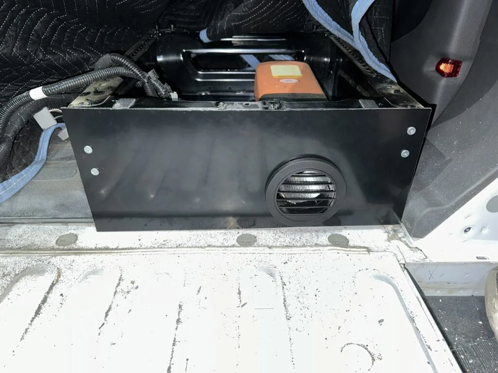 The cover and vent arrangement behind the passenger seat.