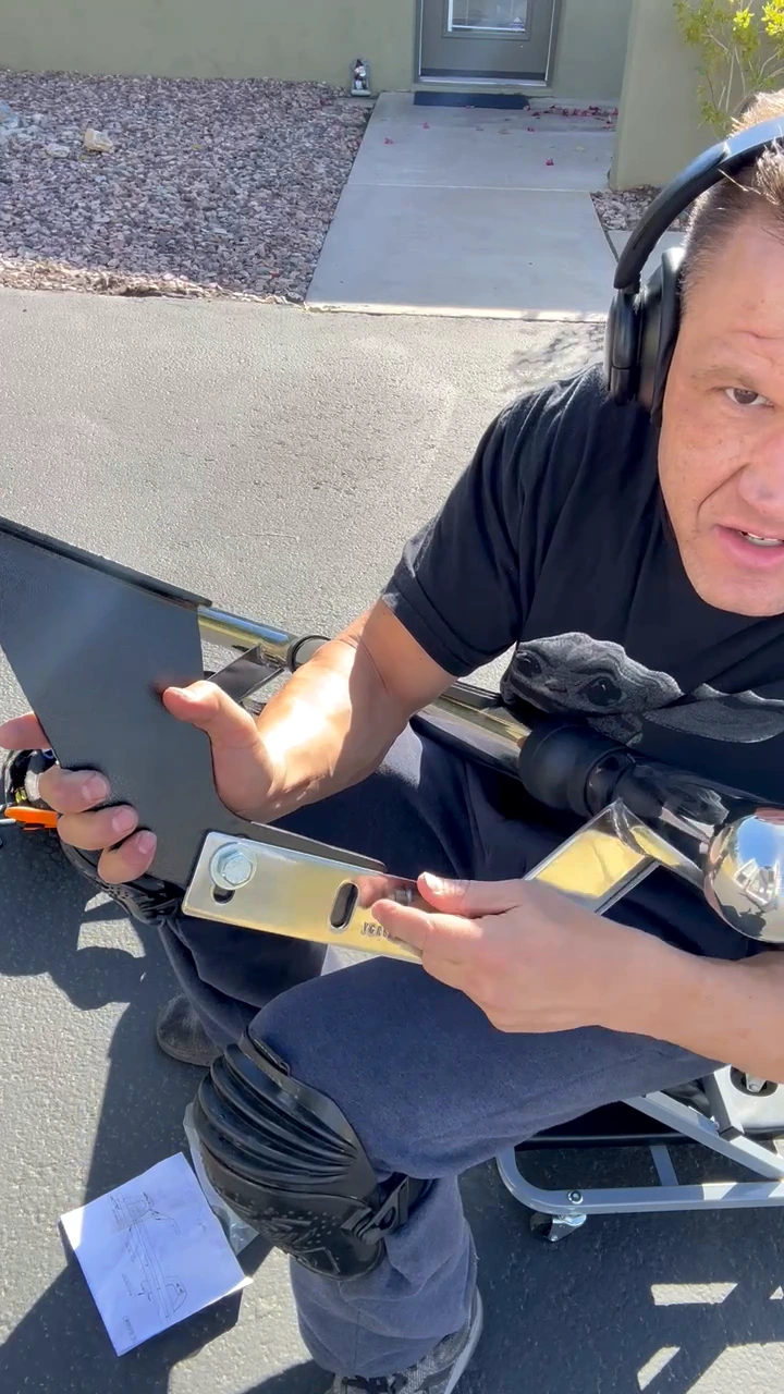Steven Smith holding the bracket and pointing at the hole region beside the chrome rear guard