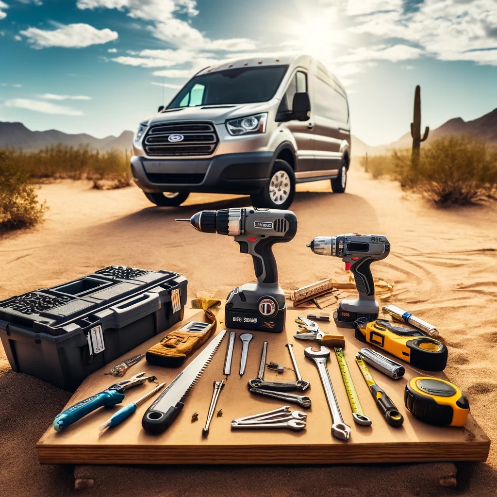 Various essential tools for van conversion, including a cordless drill, saw, and hammer, displayed on desert ground with a 2023 Ford Transit van in the background, in Phoenix, AZ.